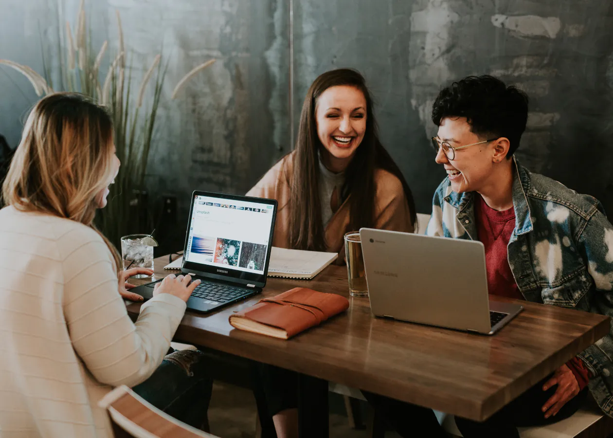 Three happy tech staff having a discussion in their office